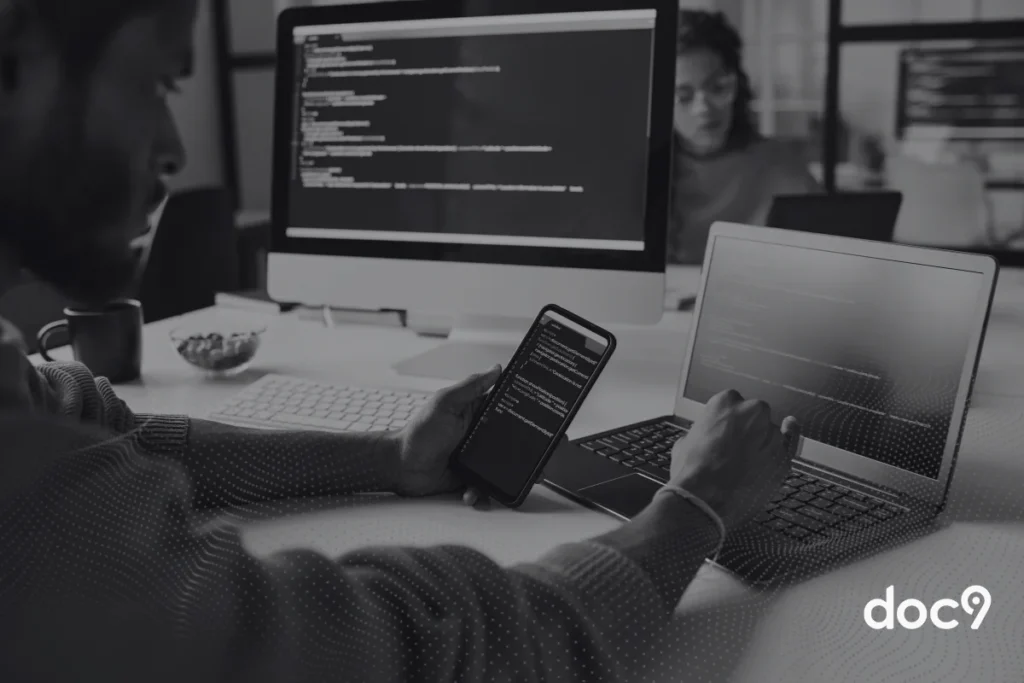 Desenvolvedor de software programando em múltiplos dispositivos com código no chatgpt em ambiente de escritório