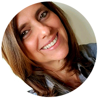 Foto de Elisane Dor sorrindo, em um fundo neutro.