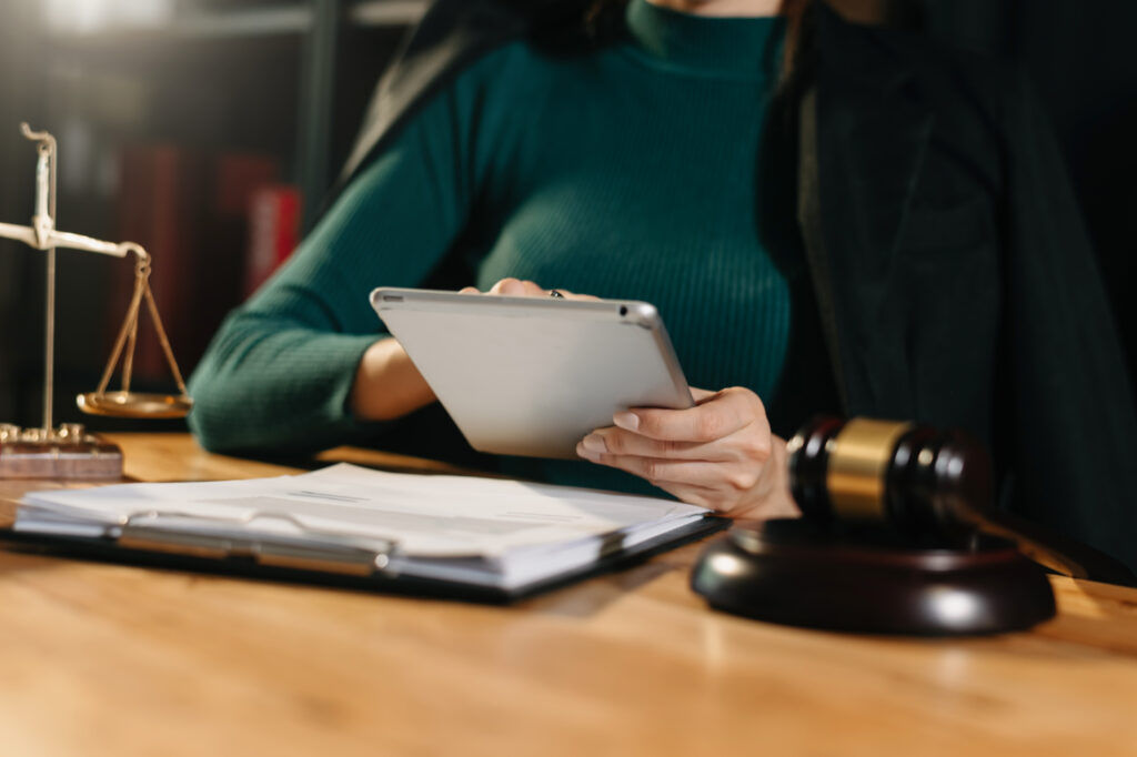 mulher em um tribunal, o martelo, trabalhando com tablet sobre mesa de madeira