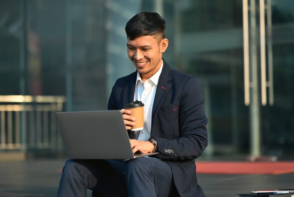 homem sentido numa escada trabalhando com um laptop no colo IA para advogados