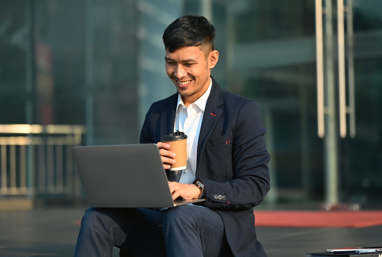 homem sentido numa escada trabalhando com um laptop no colo IA para advogados