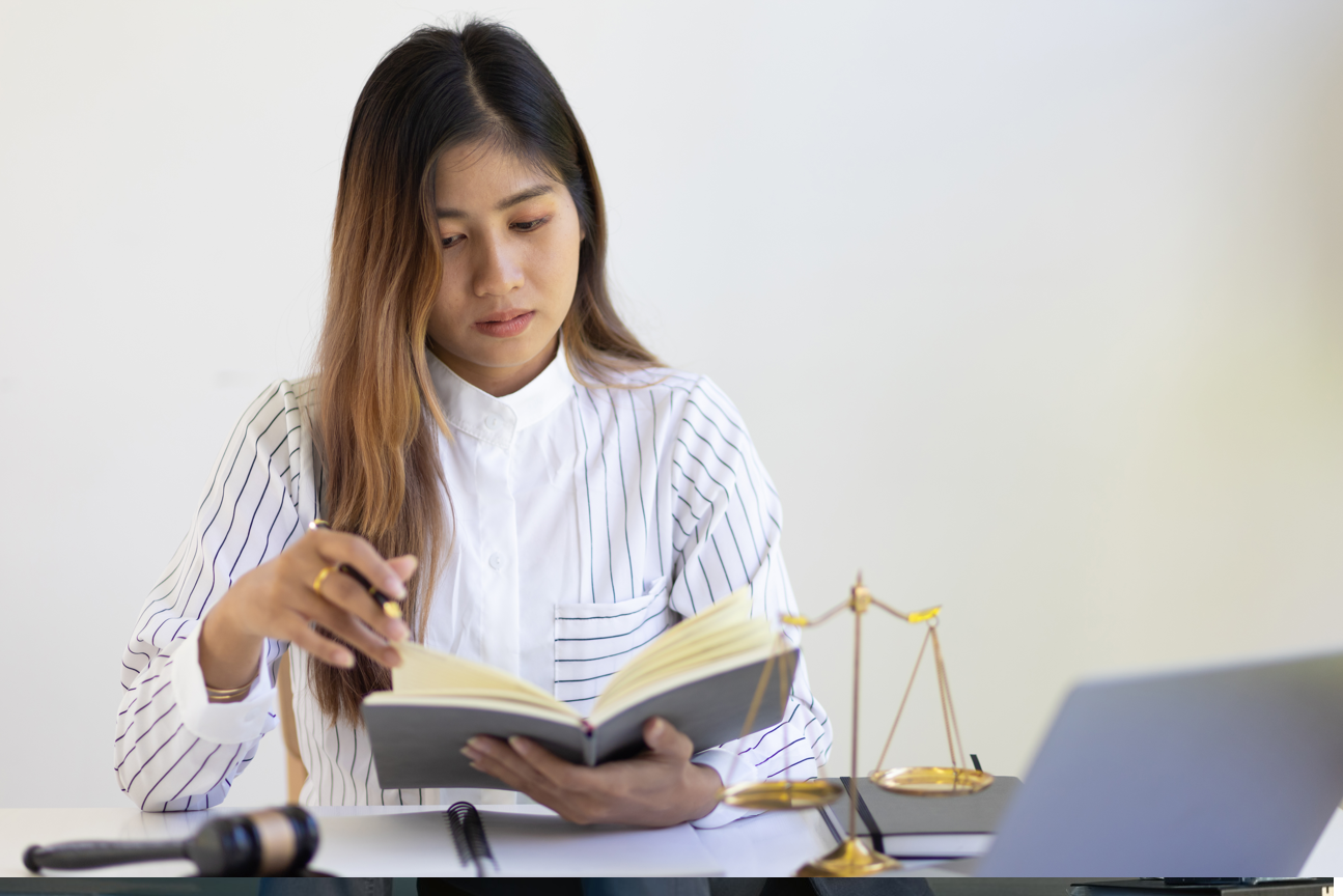 Mulher foleando um caderno pesquisa jurídica