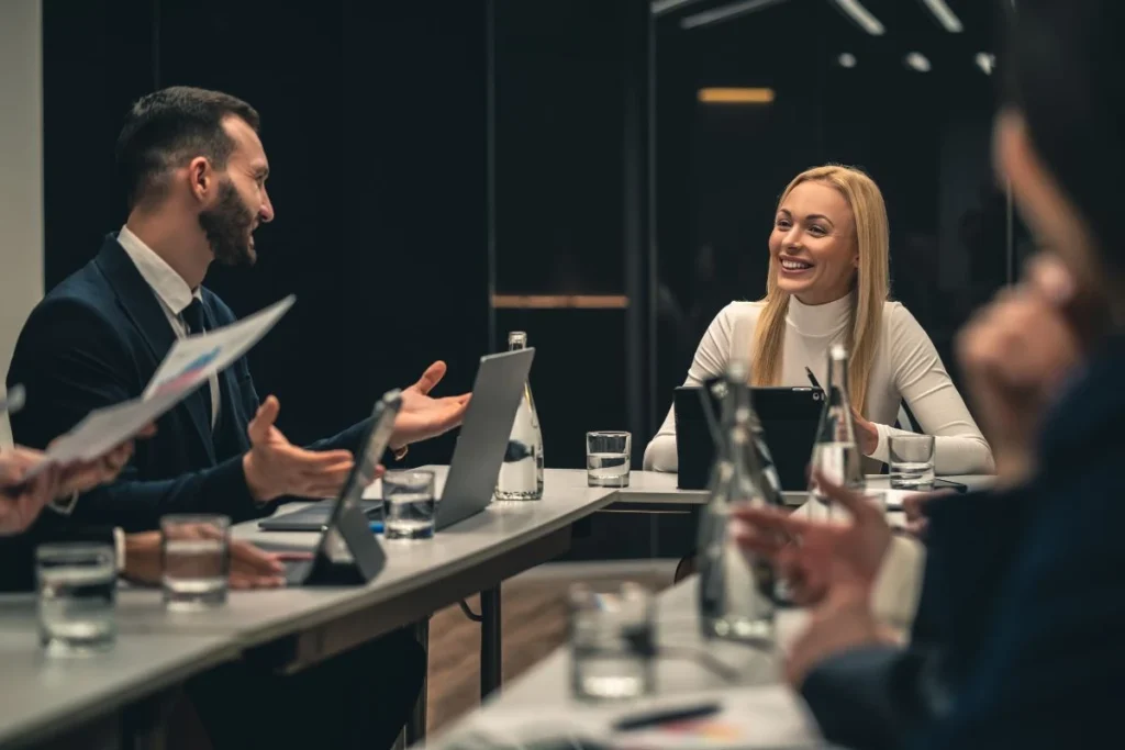 Reunião de equipe de negócios com pessoas sorridentes em uma sala moderna, discutindo estratégias e tomadas de decisão para argumentação jurídica.