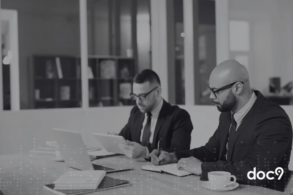 Advogados sentados fazendo anotações, representando processos jurídicos.