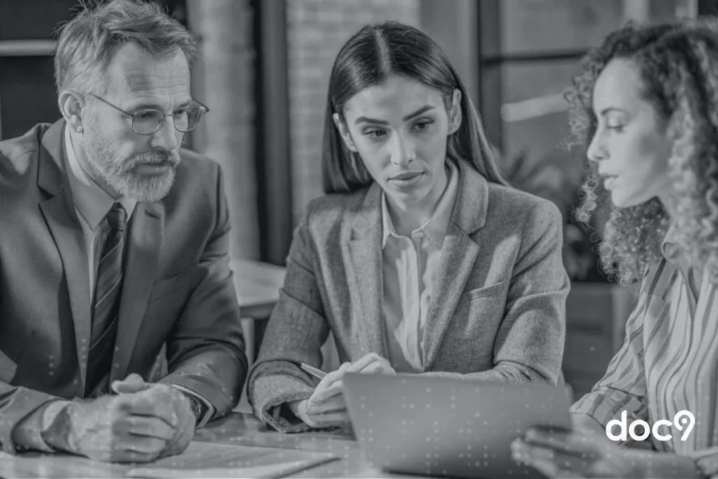Advogados reunidos olhando para um tablet, representando um contrato online gratuito.