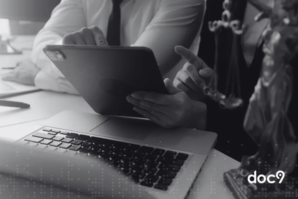 Vista lateral de dois advogados analisando um documento digital em um tablet, ilustrando um artigo da doc9 sobre tipos de certificado digital no Direito.